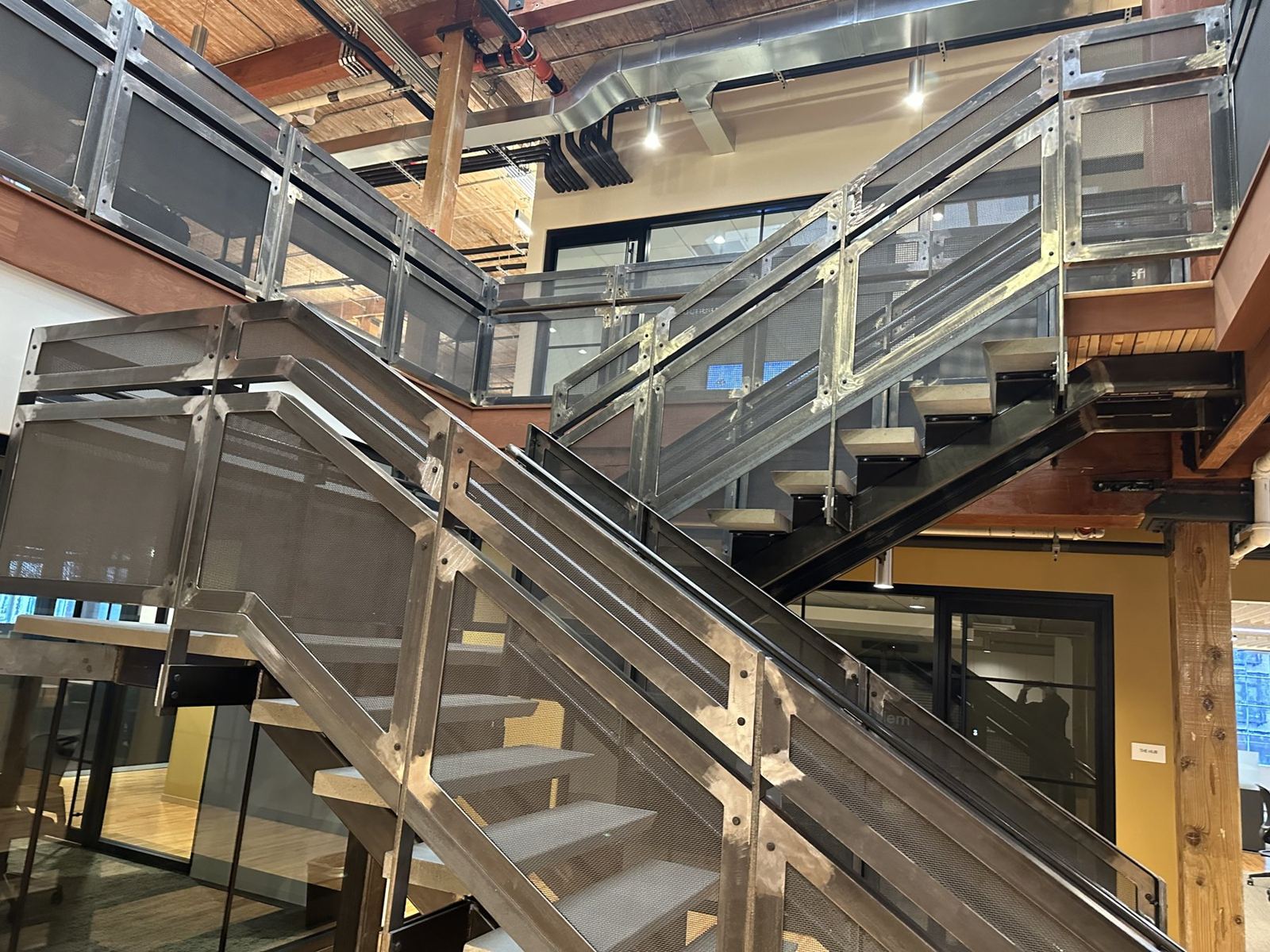 Interior steel stair with mesh guardrail panels